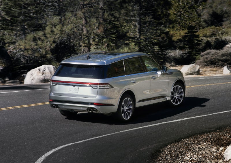A 2023 Lincoln Aviator® Grand Touring model is shown being driven on a tight turn of a mountain road | Al Packer Lincoln in West Palm Beach FL