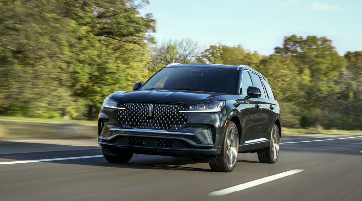 A 2025 Lincoln Black Label Aviator® SUV is being driven down a road lined with trees. | Al Packer Lincoln in West Palm Beach FL