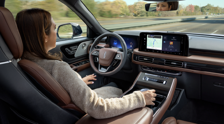 A woman is seen sitting in the driver’s seat of her 2025 Lincoln Aviator® SUV with her hands off the steering wheel. | Al Packer Lincoln in West Palm Beach FL