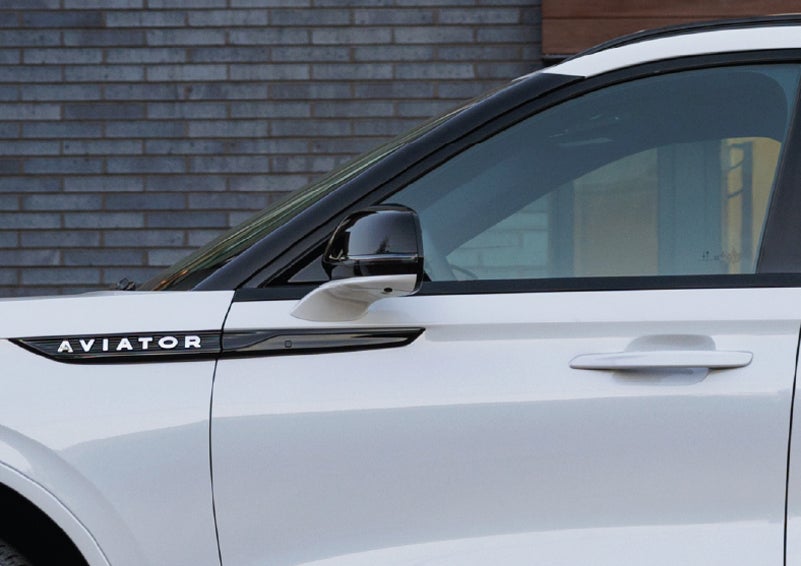 The driver’s side door and fender badging of a white 2026 Lincoln Aviator® SUV are showcased. | Al Packer Lincoln in West Palm Beach FL