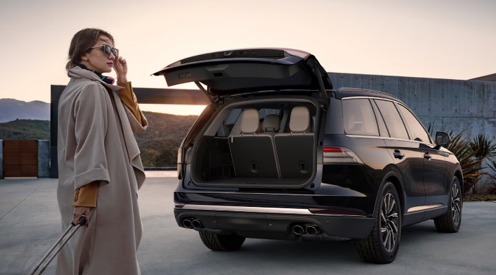 A woman approaches a 2026 Lincoln Aviator® SUV with its rear liftgate open. | Al Packer Lincoln in West Palm Beach FL
