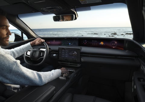 A driver of a parked 2026 Lincoln Nautilus® SUV takes a relaxing moment at a seaside overlook while inside his Nautilus. | Al Packer Lincoln in West Palm Beach FL