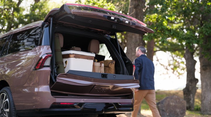 A woman approaches a parked 2025 Lincoln Navigator® SUV with its Split Gate open.