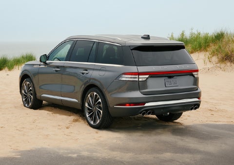 A 2027 Lincoln Aviator® SUV is parked next to sand dunes. | Al Packer Lincoln in West Palm Beach FL