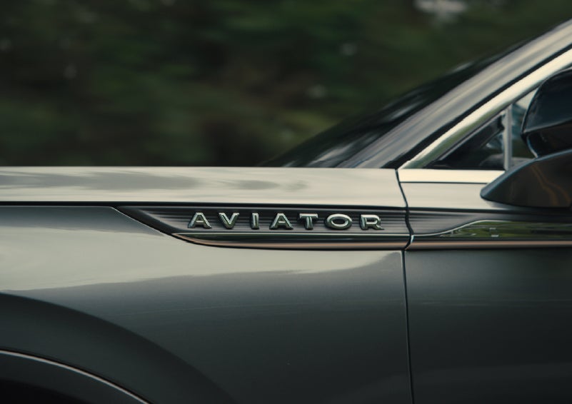 The driver’s side door and fender badging of a gray 2027 Lincoln Aviator® SUV are showcased. | Al Packer Lincoln in West Palm Beach FL
